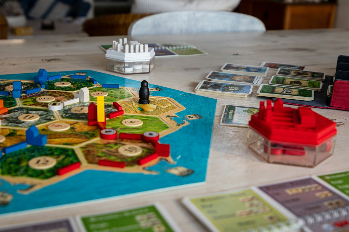 Catan game set up on a wooden table with colorful pieces.