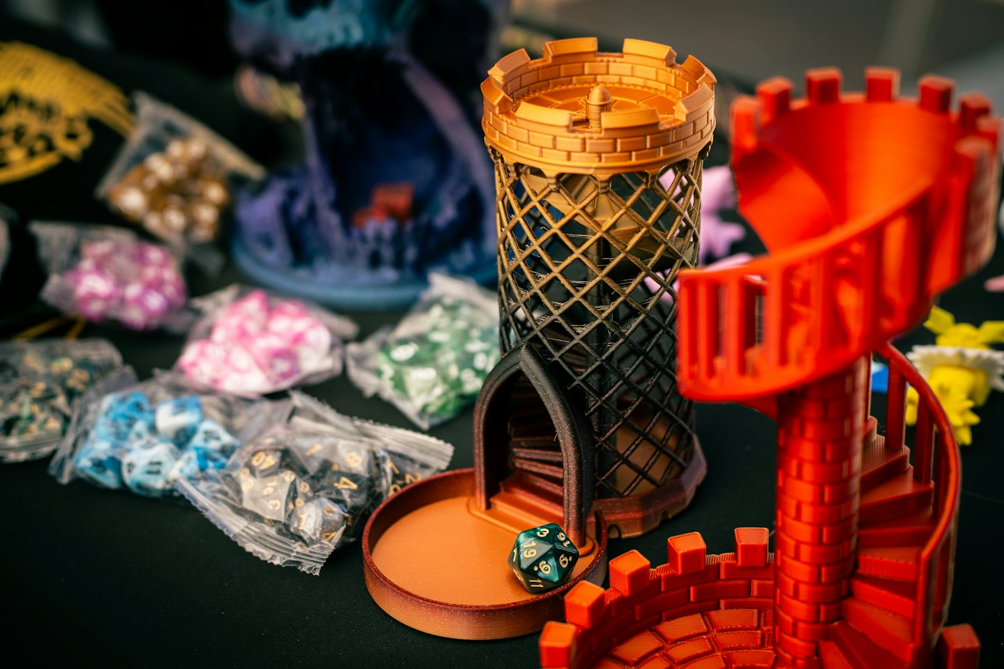 Two 3D printed dice towers with dice and bags of dice.