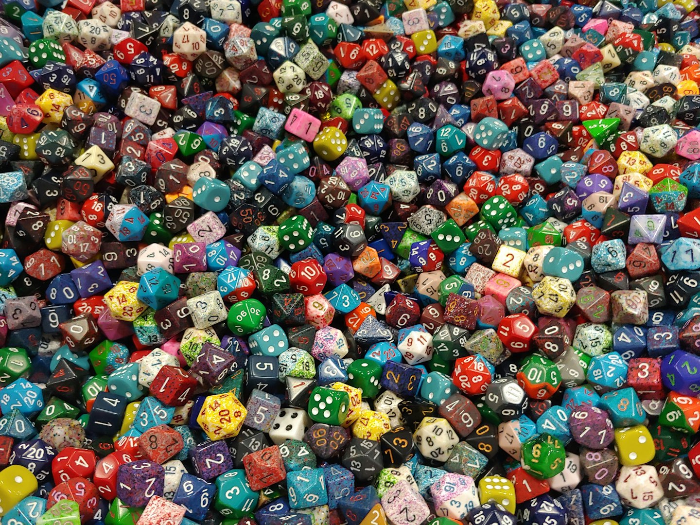 Assorted colorful polyhedral dice piled together for tabletop games.